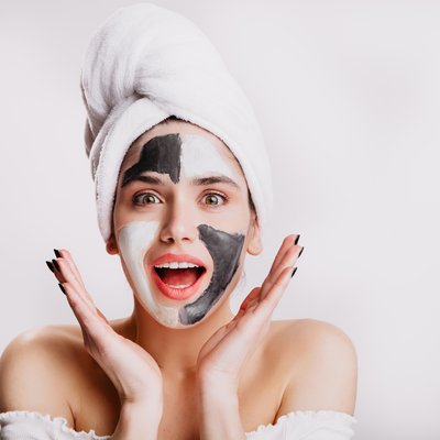 joyful-girl-with-face-mask-surprise-green-eyed-woman-posing-white-wall-after-washing-her-hair