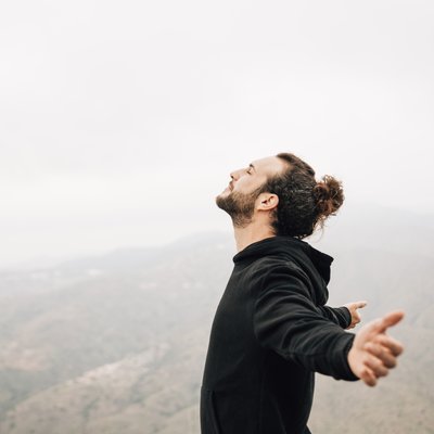 side-view-carefree-man-enjoying-freedom-with-arms-outstretched