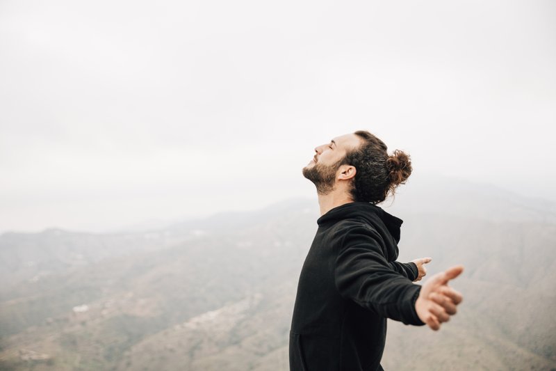 side-view-carefree-man-enjoying-freedom-with-arms-outstretched