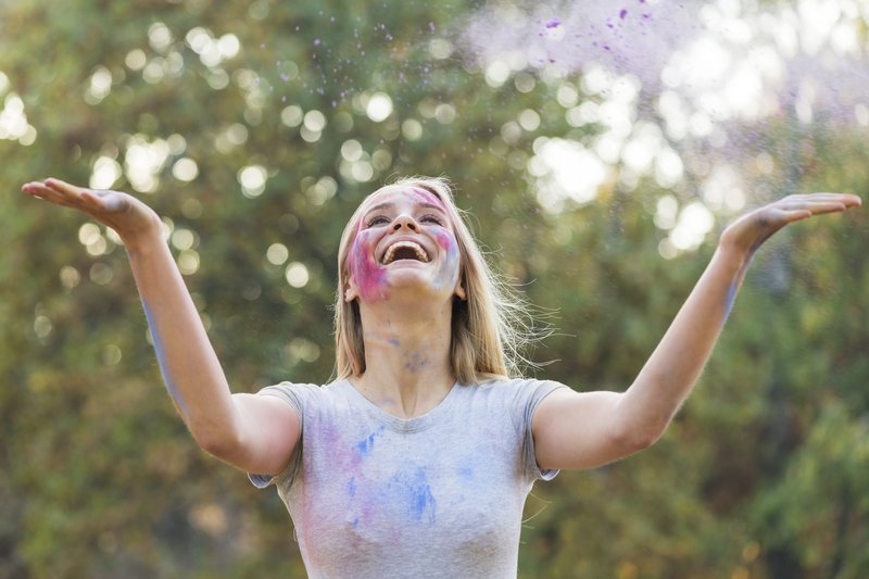 werfende-farbe-der-gluecklichen-frau-in-der-luft